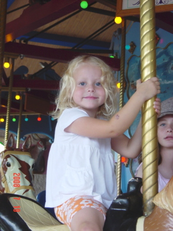 bella on the merry go round at the zoo