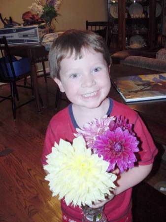 my son holding flowers I grew in my garden