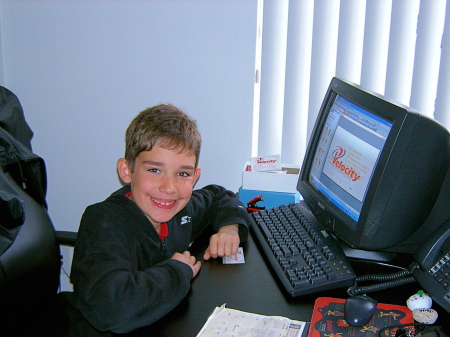 C.J., 8 years old, the computer whiz, at Daddy's desk