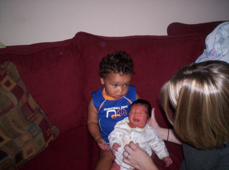 Braylin taking lessons on how to hold baby brother