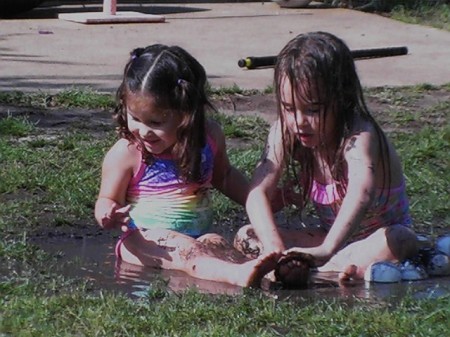 grandchildren playing in water sprinkler