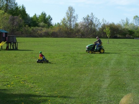 Elliott helping Dad mow the grass