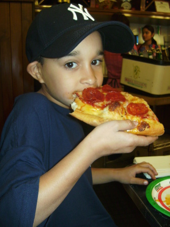 Logan enjoying a slice of New York pizza.