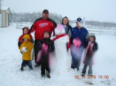 Steph and Tim build snowman with all 4 kids