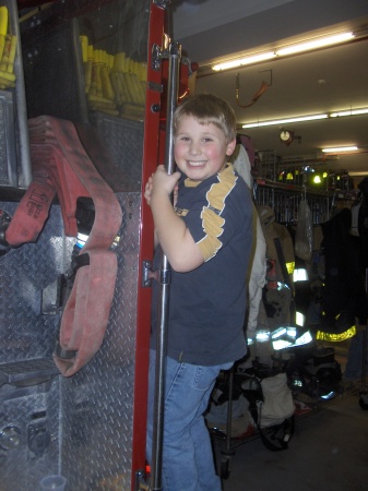 Tommy hanging on to a fire truck