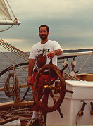 at the helm of the Malabar on Traverse Bay