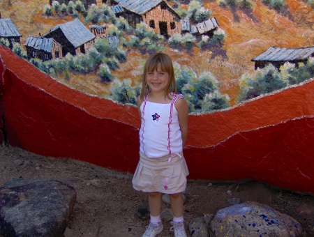 My daughter in front of a painted mural on a large rock in Chloride, AZ
