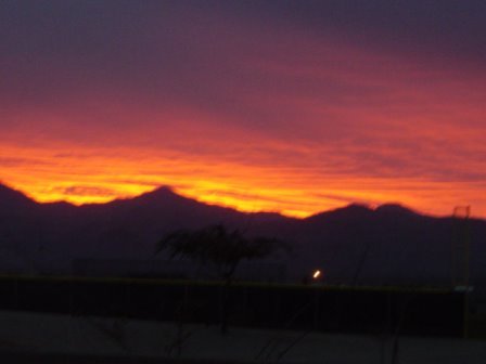 View of the sun setting behind the mountains from my home