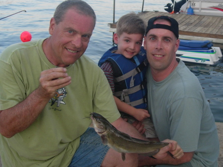 Pappaw, Harrison, & Greg posing with a fish at the river.