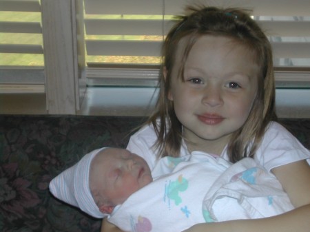 My daughter holding her new baby brother.