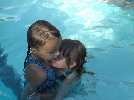 Our girls swimming and hugging during a visit to Montana last summer.