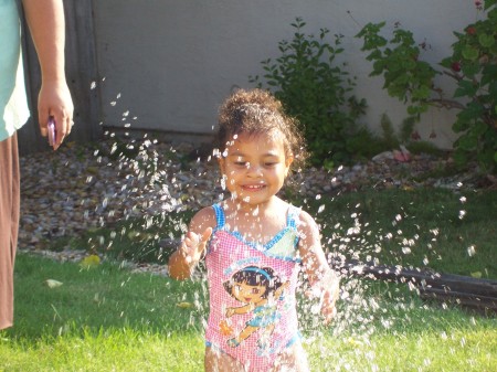 ava playing in the sprinkler