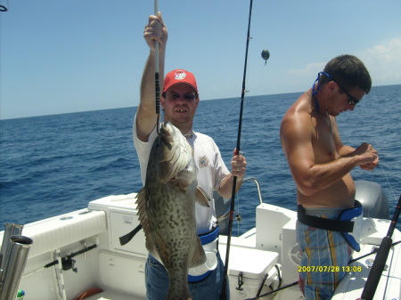 my husband holding his grouper fish he caught