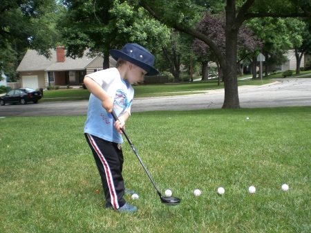 Tyler playing golf in the front yard.