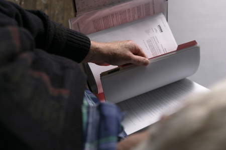 Ron Price turning pages of his files