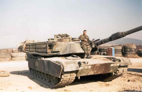Rick standing on tank in bosnia