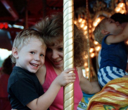 Me & Eric on Carousel [christopher trying to climb the pole :)]