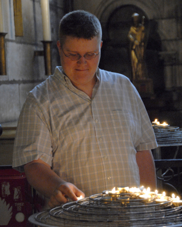 Devin lighting a prayer candle at Notre Dame