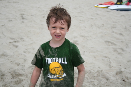 My 5 year-old grandson covered in sand.
