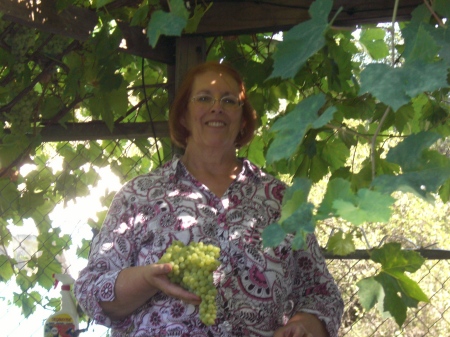 Tina under her grape arbor