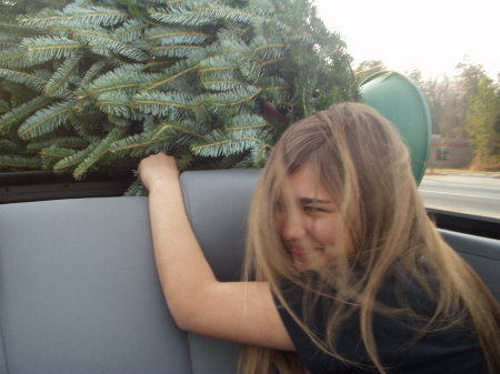 my daughter holding the Christmas tree