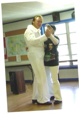 An Elvis show-dancing with a fan