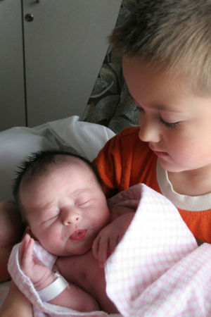 The big brother holding his new baby sister!