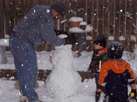 Daddy, building a snowman with the little ones