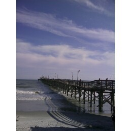 BLUE SKIES AND PIER ON BEACH