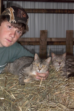 Our third son Reece with our barn cats