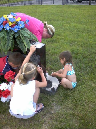 Kids taking care of Paw Paw's grave