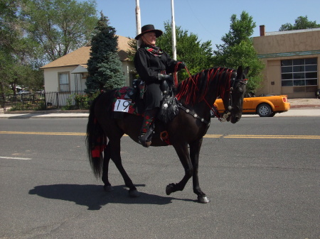 Andrea riding her horse, Satin, in parade.