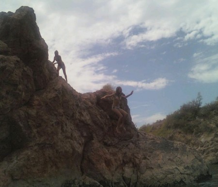 Savhanna jumping off a cliff at the river