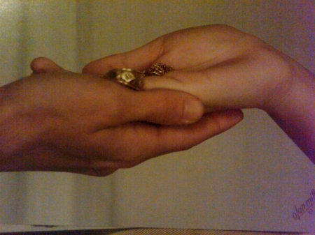 My kids hands holding their dad's wedding ring