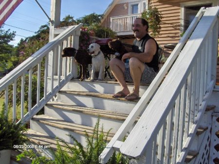 Scott and puppies on porch.