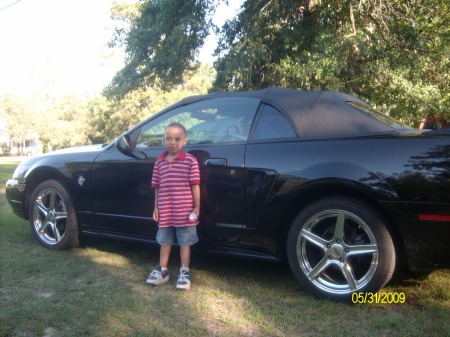 My grandson posing beside his new mustang!