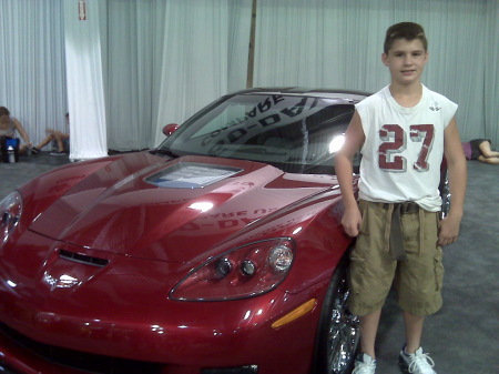 Travis Colton posing with his dream car