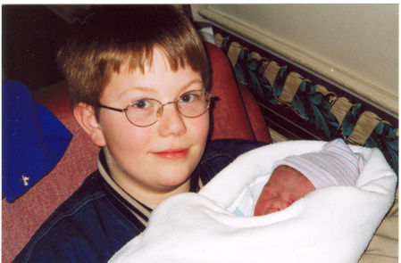 oldest son holding his sister for the 1st time
