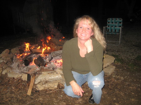 Cathy in front of camp fire behind her house