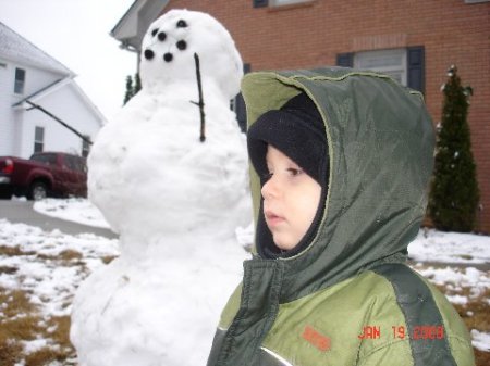 tyler in front of neighbor's snowman