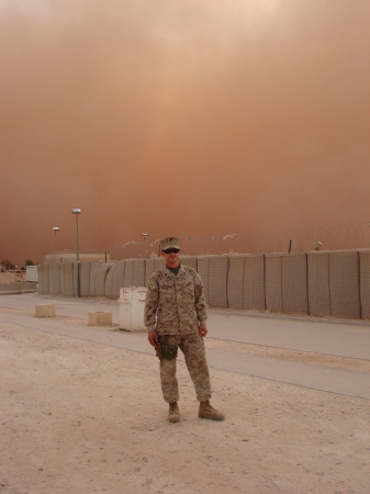MY HUSBAND IN IRAC WITH A SAND STORM BEHIND HIM