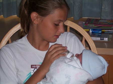 My fourteen year old daughter holding my grandson