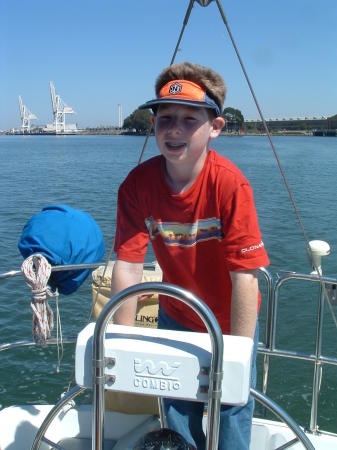 Nick, age 13, navigating our sailboat on the bay