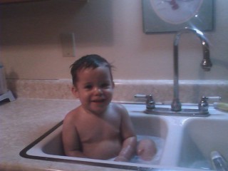 Gregory taking a bath in the kitchen sink