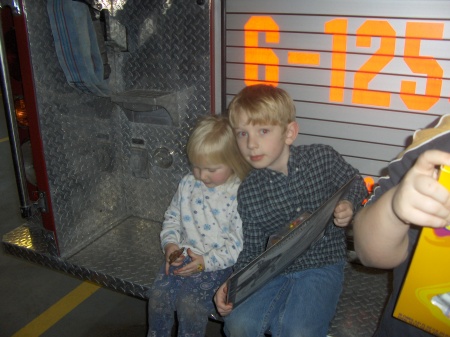 Jessica and Mike Jr. on the back of a fire truck