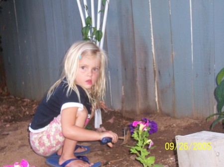 Darian planting flowers in her Grandma's big shoes!