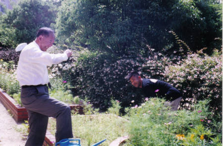 Japanese PRINCIPAL helping the plant manager weed the garden...