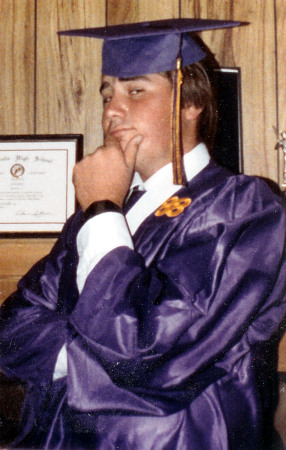 chris posing in hs graduation robes