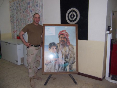 Posing with Saddam's picture
