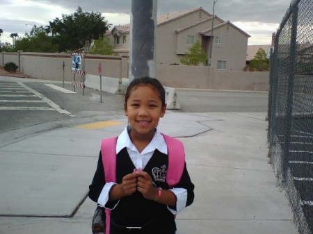 shaina in front of her school first grade